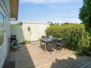 海斯勒Holiday Home Eliene - 400m from the sea in Bornholm by Interhome的木制甲板上配有桌椅的天井