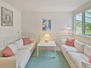 瓦伊厄斯斯特兰德Holiday Home Gaelle - 800m from the sea in Western Jutland by Interhome的客厅配有2张白色沙发和1张桌子