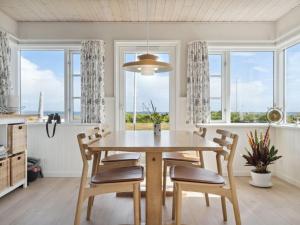 AsperupHoliday Home Mirkka - 50m from the sea in Funen by Interhome的一间带桌椅和窗户的用餐室
