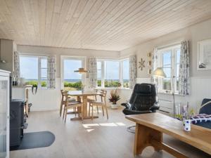 AsperupHoliday Home Mirkka - 50m from the sea in Funen by Interhome的客厅配有桌椅和窗户。