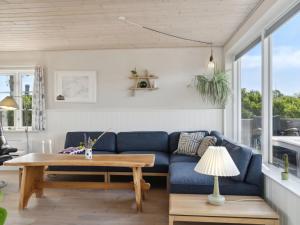 AsperupHoliday Home Mirkka - 50m from the sea in Funen by Interhome的客厅配有蓝色的沙发和桌子