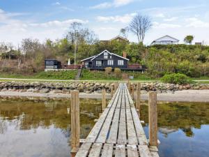 RoslevHoliday Home Sander - 10m to the inlet in The Liim Fiord by Interhome的一座木桥,在水体上,有房子