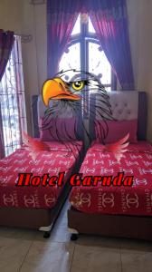 RambahHotel Garuda的一只鹰在房间床上的画