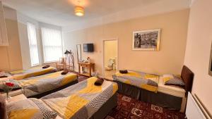 利物浦Castle Lodge Guest House 86-88 Sheil Rd L6 3AF的一间客房内设有四张床的房间