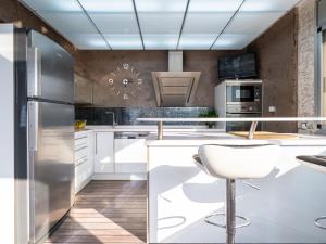 雷乌斯Villa Villa Luxury Rock Tirri by Interhome的厨房配有白色橱柜和白色椅子