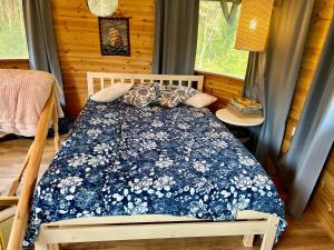 ReigiRoosa maja parvesaunaga的一间卧室配有一张带蓝色和白色棉被的床
