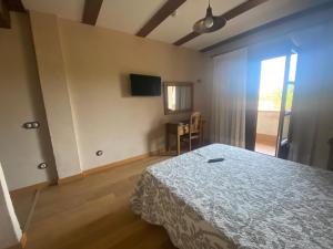 阿尔德亚达维拉德拉里韦拉Hotel Rural Centro de las Arribes的一间卧室配有一张床、一张桌子和一个窗户。