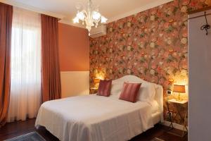 乌尔比诺Residenza Ambrogi的一间卧室配有一张带花卉壁纸的床