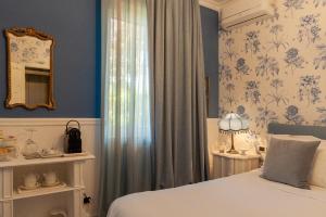 乌尔比诺Residenza Ambrogi的一间拥有蓝色墙壁、一张床和镜子的卧室