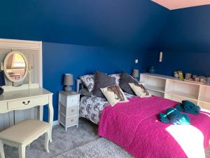 康斯坦丁Silverspring Farm En suite的蓝色的客房配有床、书桌和镜子