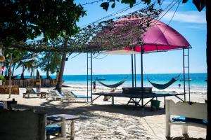 迪亚尼海滩Soul Breeze Backpackers Diani的海滩上的野餐桌椅和遮阳伞