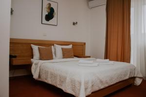 莫伊科瓦茨Hotel Serdar的一间卧室配有一张床,上面有两条毛巾