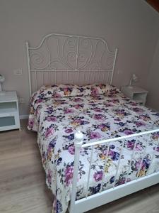 MonzunoRELAIS AGADELLO的卧室内的白色床和花卉棉被