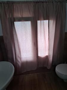 MonzunoRELAIS AGADELLO的浴室设有粉红色的窗帘、卫生间和水槽。