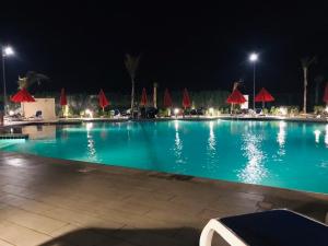 塞得港Porto Said Resort Rentals的一座带红伞的大型游泳池