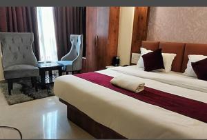 古瓦哈提HOTEL DAISY的酒店客房带一张大床和一把椅子