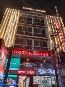 古瓦哈提HOTEL DAISY的前方有 ⁇ 虹灯标志的酒店大楼