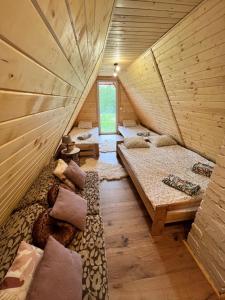 拉伊恰Domek nad Potokiem w Beskidach的木屋内的一个房间,配有三张床