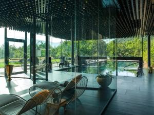 蒙塔尼亚Manna Resort的一间设有玻璃墙、椅子和桌子的房间