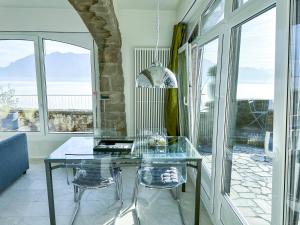 PuidouxPanoramic Room in the vineyard,stunning views of lake and Alps的窗户间里的玻璃桌和椅子