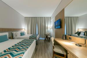 卡布雷乌瓦Japy Golf Resort Hotel的酒店客房配有两张床和一张书桌