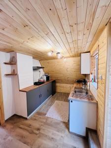 拉伊恰Domek nad Potokiem w Beskidach的厨房设有木墙和木制天花板。
