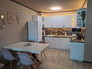 索非亚All Season’s Apartment的厨房配有白色橱柜和桌椅