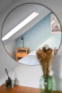 埃特勒塔LA DAME - ETRETAT的镜子反射着卧室,卧室配有床和梳妆台