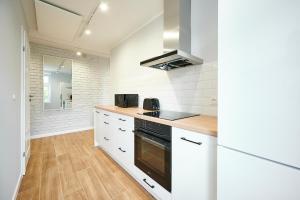 奥尔什丁Apartament Barczewski, 2 pokoje i kuchnia的厨房配有白色橱柜和炉灶烤箱。