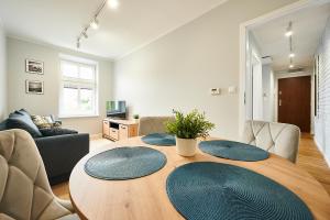 奥尔什丁Apartament Barczewski, 2 pokoje i kuchnia的客厅配有带蓝色盘子的木桌