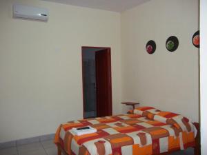 伊基托斯Casa Linda II的一间卧室配有一张带橙色和白色棉被的床