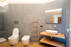 卡萨尔韦利诺Isola Verde的一间带卫生间、水槽和镜子的浴室