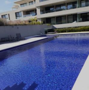 蒙得维的亚Descanso garantizado!的大楼前的大型蓝色游泳池