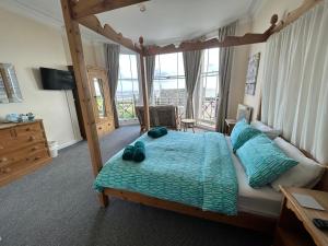 洛斯托夫特邦阿米旅馆的一间卧室配有一张带蓝色枕头的天蓬床