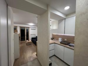 泽尼察Apartman Sara的一间带白色橱柜的厨房和一间客厅