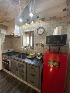 塞特尼尔Tajito Romano的厨房配有红色冰箱和微波炉