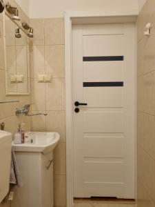 格丁尼亚Apartament 51的浴室设有水槽旁的白色门