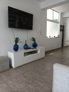 蓬塔赫尔莫萨Departamento en Punta Hermosa con vista al Mar的一间客厅,在白色的橱柜上摆放着两只蓝色花瓶