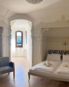 米尔施塔特施特莱恩茨别墅酒店的一间卧室配有一张大床和一把椅子