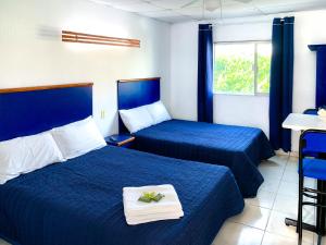 瓜达拉哈拉La Casa del Expositor的酒店客房,配有两张带蓝色床单的床