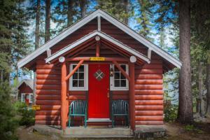 路易斯湖伊甸园洋房旅舍的小木屋配有两把椅子和一扇红色门