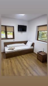 阿尔杰什河畔库尔泰亚Popas Momaia的卧室配有一张床,墙上配有电视。