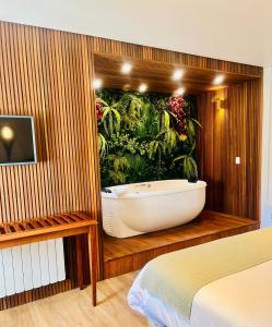 坎波斯杜若尔当阿尔弗雷多何塞宾馆的带浴缸的浴室,配有植物壁画