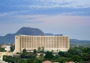 阿布贾特兰斯克普阿布贾希尔顿酒店的一座白色的大建筑,背景是一座山