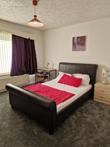 塔姆沃思Chimes-Company & Family Stay, 2 Bedroom House + Free parking的一间卧室配有一张带红色毯子的大床