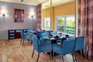 亚历山大亚历山大绿色广场希尔顿酒店的一间配备有蓝色椅子和桌子的用餐室