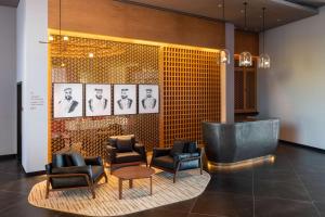 阿布扎比The WB Abu Dhabi, Curio Collection By Hilton的大堂设有椅子和桌子,墙上挂有图片