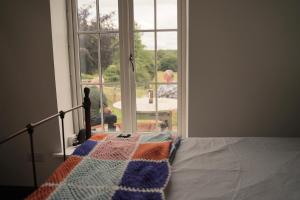 Worfe View Cottage的一间卧室设有一张床和一个开放式窗户。