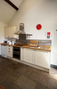 Worfe View Cottage的厨房配有白色橱柜和水槽