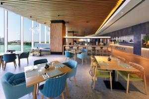 麦纳麦Hilton Garden Inn Bahrain Bay的餐厅设有木制天花板和桌椅